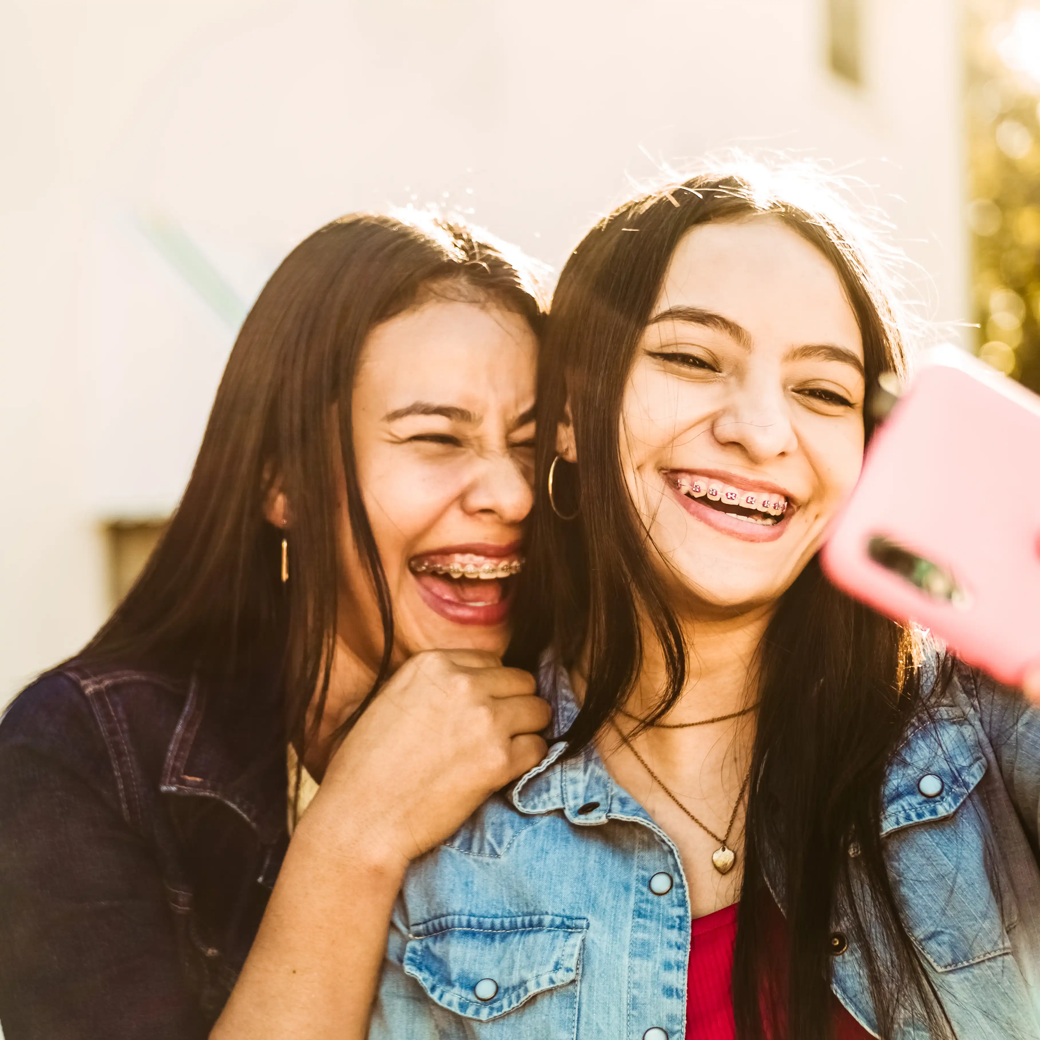 Two young girls smiling with braces.